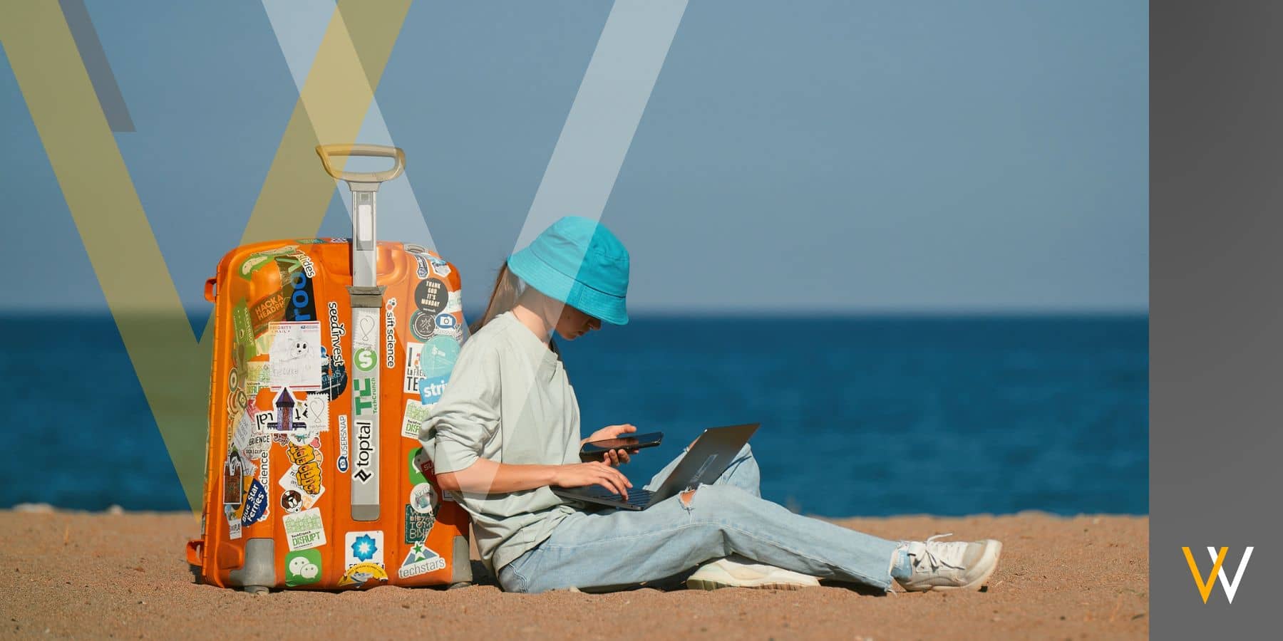 a woman leaning on a suitcase at the sea while working on a laptop